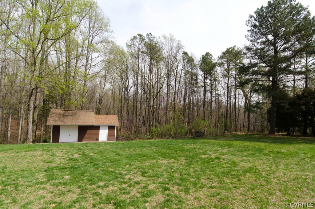 2209 Kings Lynn Road Midlothian, VA 23113 - Photo 5 of 24 a front view of house with yard and trees in the background