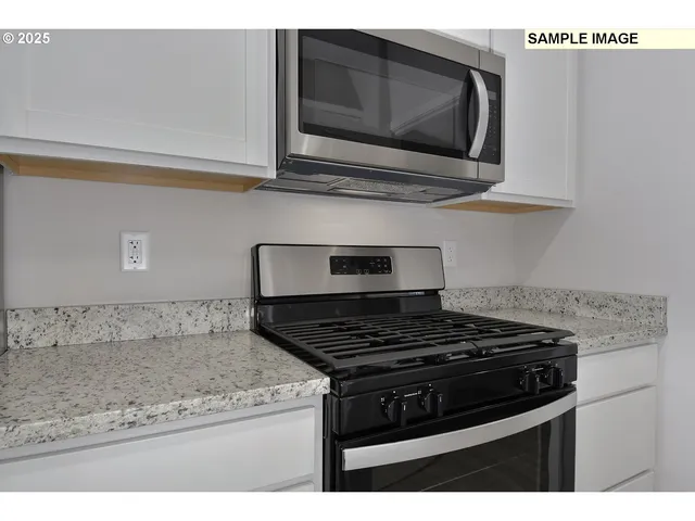 a kitchen with stainless steel appliances granite countertop a stove and a microwave