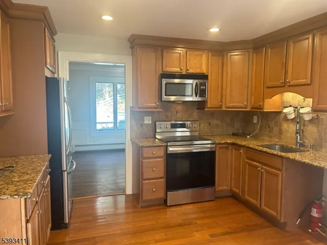 a kitchen with stainless steel appliances granite countertop a stove a sink and a microwave