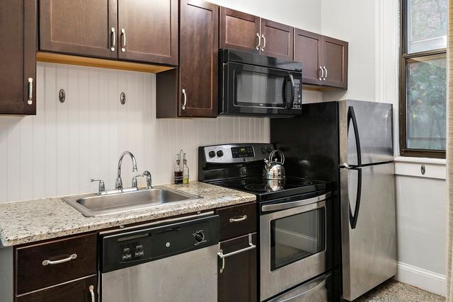 a kitchen with stainless steel appliances granite countertop a sink stove and refrigerator