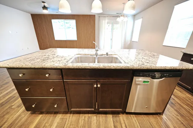 a room with granite countertop a sink and a mirror
