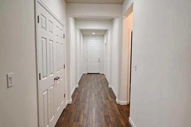 a view of a hallway with wooden floor and staircase