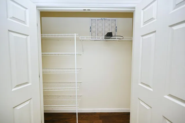 a view of walk in closet with empty racks