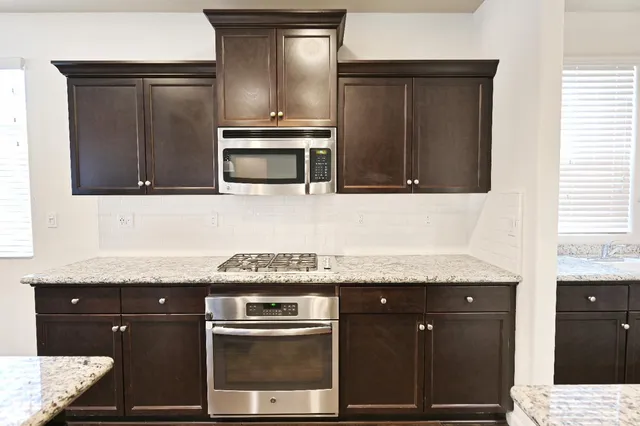 a kitchen with granite countertop stainless steel appliances and cabinets