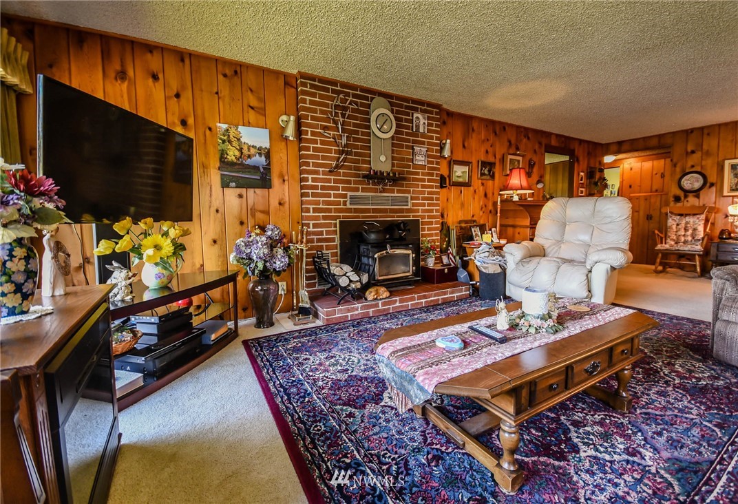 5425 Blvd Ext Road Southeast Olympia, WA 98501 - Photo 21 of 29 a living room with furniture flat screen tv and a fireplace