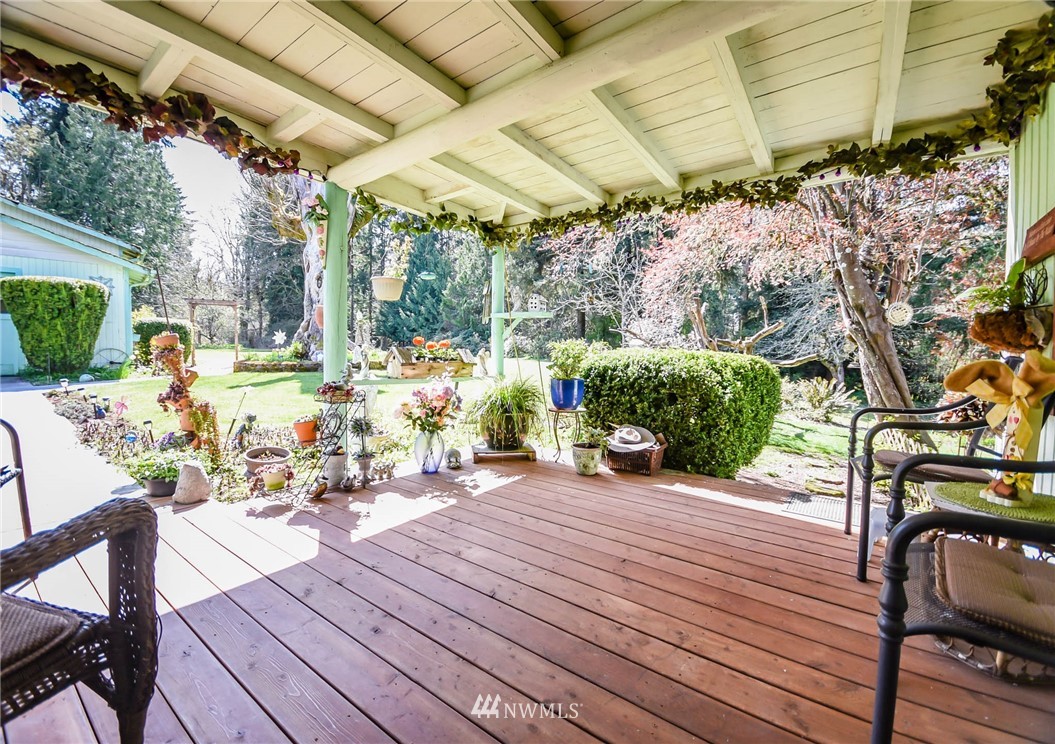 5425 Blvd Ext Road Southeast Olympia, WA 98501 - Photo 10 of 29 a view of a patio with table and chairs potted plants with wooden floor