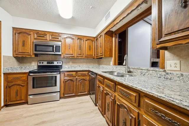 a kitchen with stainless steel appliances granite countertop a stove and a sink