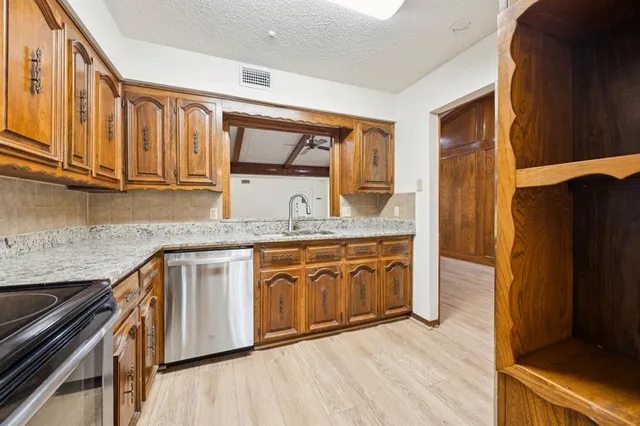 a kitchen with stainless steel appliances granite countertop a sink stove and refrigerator