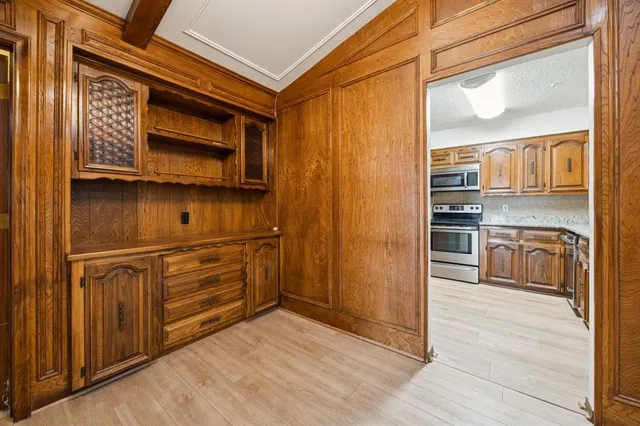 a kitchen with stainless steel appliances cabinets and a wooden floor