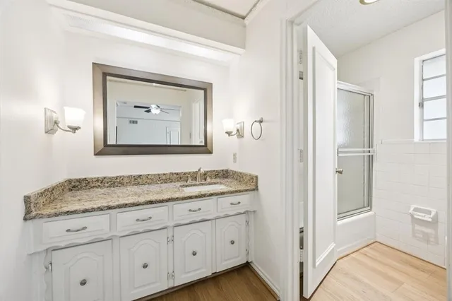 a bathroom with a granite countertop sink vanity and mirror