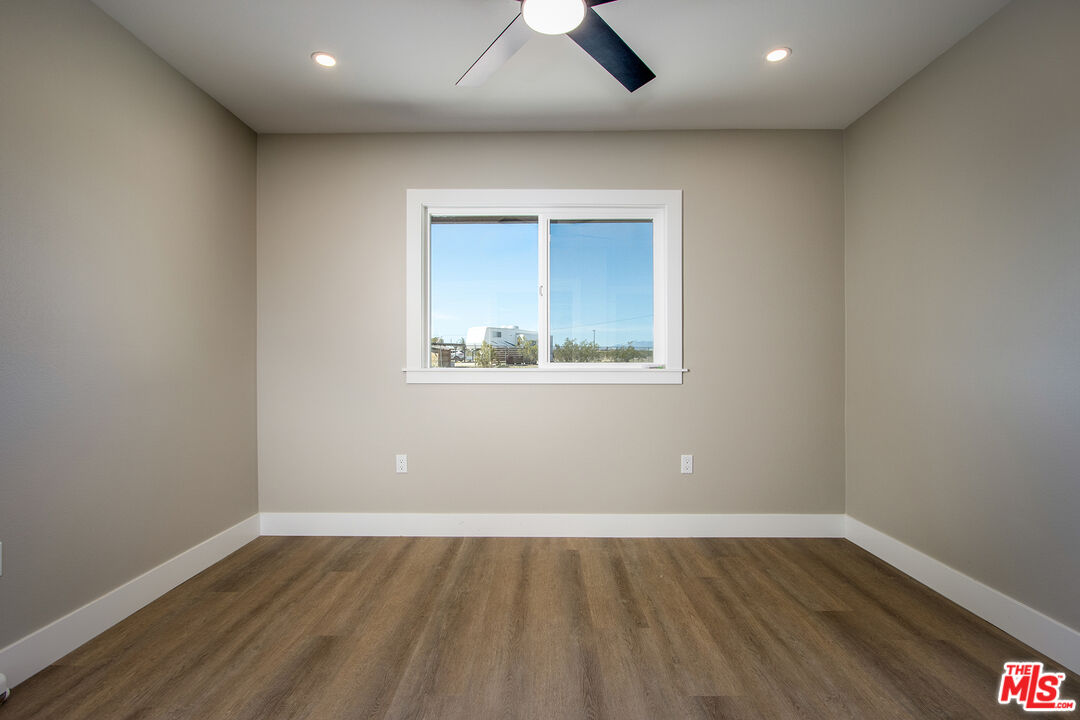 60777 Adele Road Landers, CA 92285 - Photo 22 of 43 an empty room with wooden floor and windows