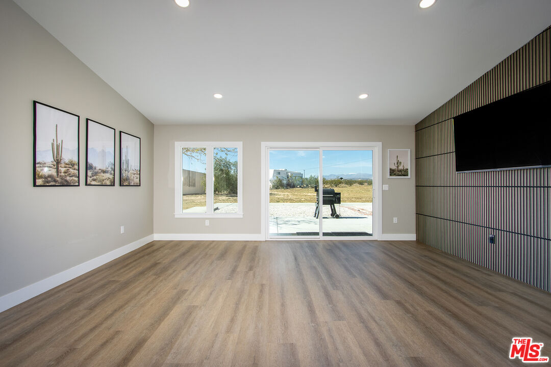 60777 Adele Road Landers, CA 92285 - Photo 10 of 43 a view of a livingroom with wooden floor and a flat screen tv