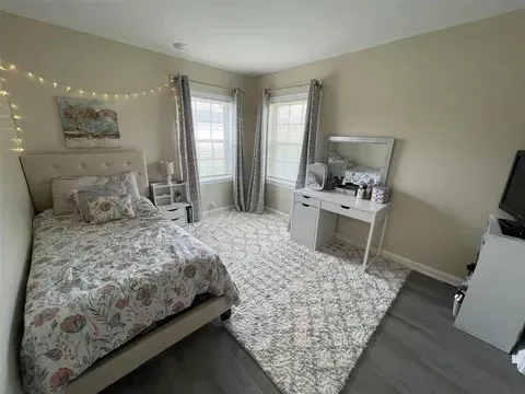 a bedroom with a bed a rug and wooden floor