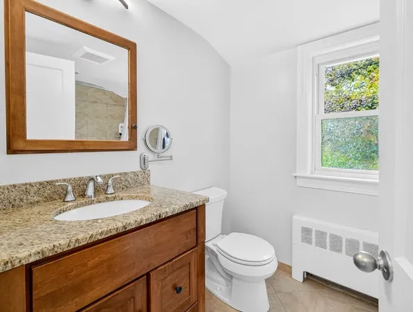 a bathroom with a granite countertop sink a toilet and a mirror