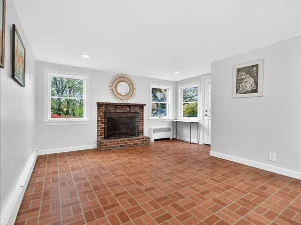 a view of an empty room with window and fireplace