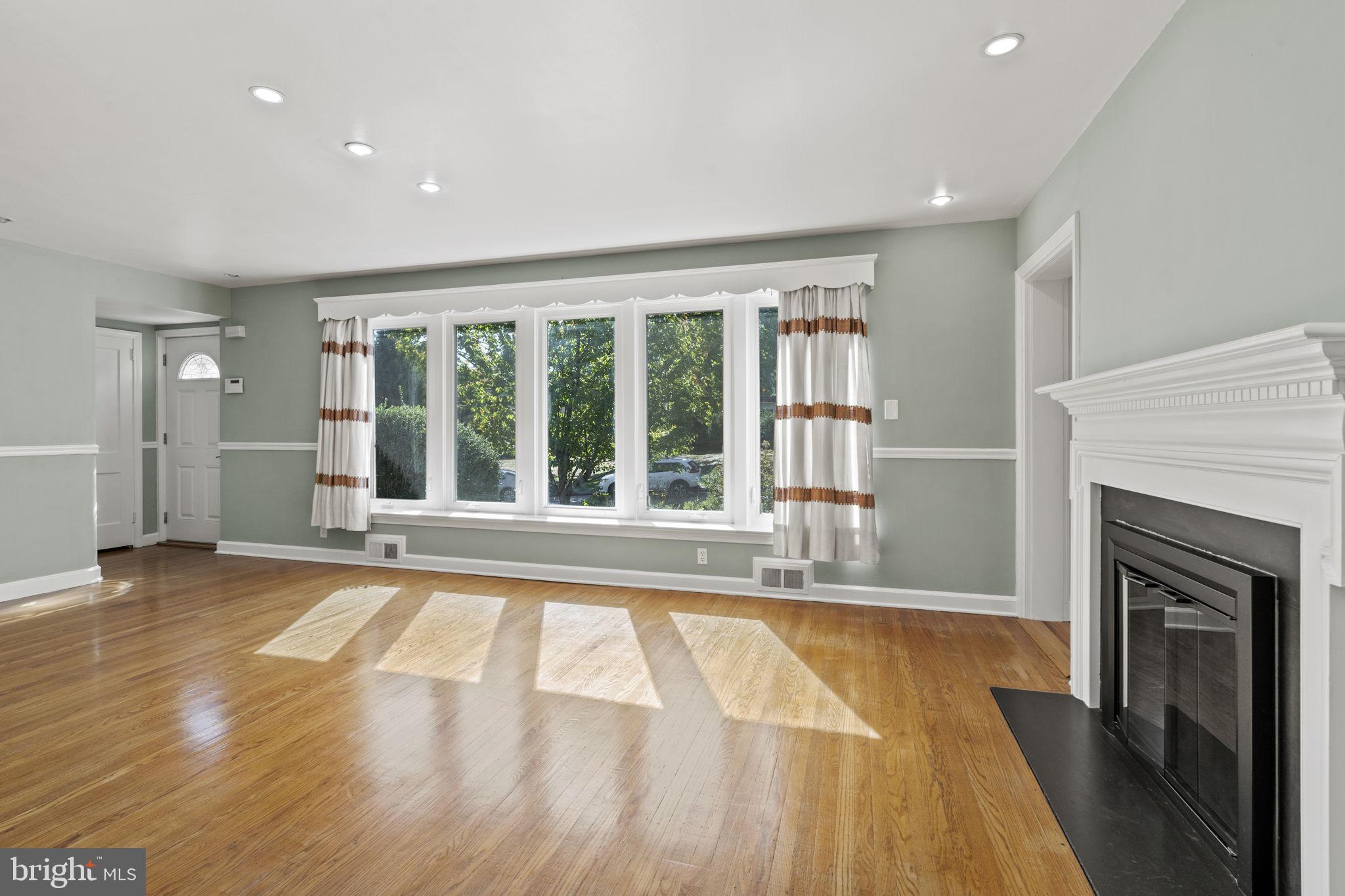 1007 Nicholson Road Wynnewood, PA 19096 - Photo 6 of 29 a view of an empty room with wooden floor and a fireplace