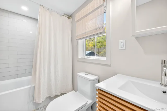 a bathroom with a toilet a sink and a window