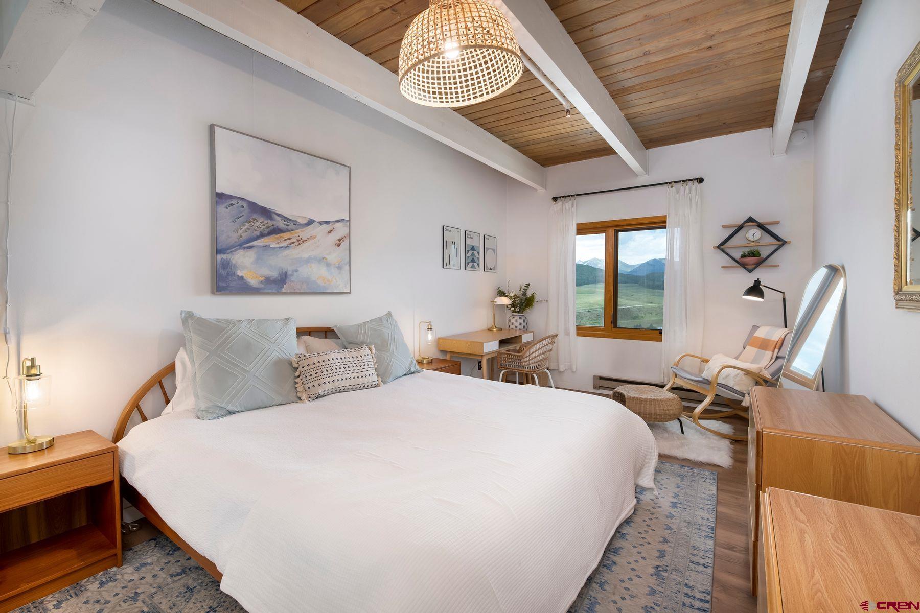 32 Hunter Hill Road, Unit B204 Crested Butte, CO 81225 - Photo 12 of 33 a bed room with a bed and a chandelier