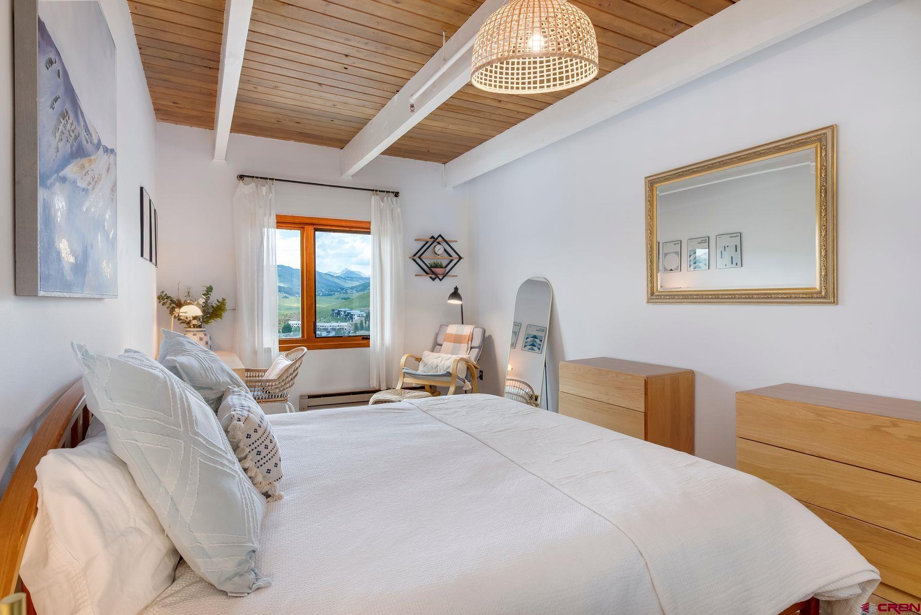 32 Hunter Hill Road, Unit B204 Crested Butte, CO 81225 - Photo 13 of 33 a bedroom with a bed and a chandelier