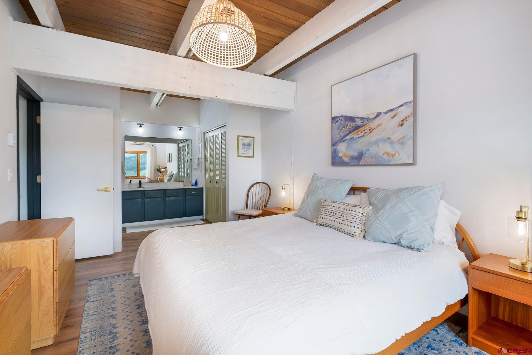 32 Hunter Hill Road, Unit B204 Crested Butte, CO 81225 - Photo 15 of 33 a bedroom with a bed and a chandelier