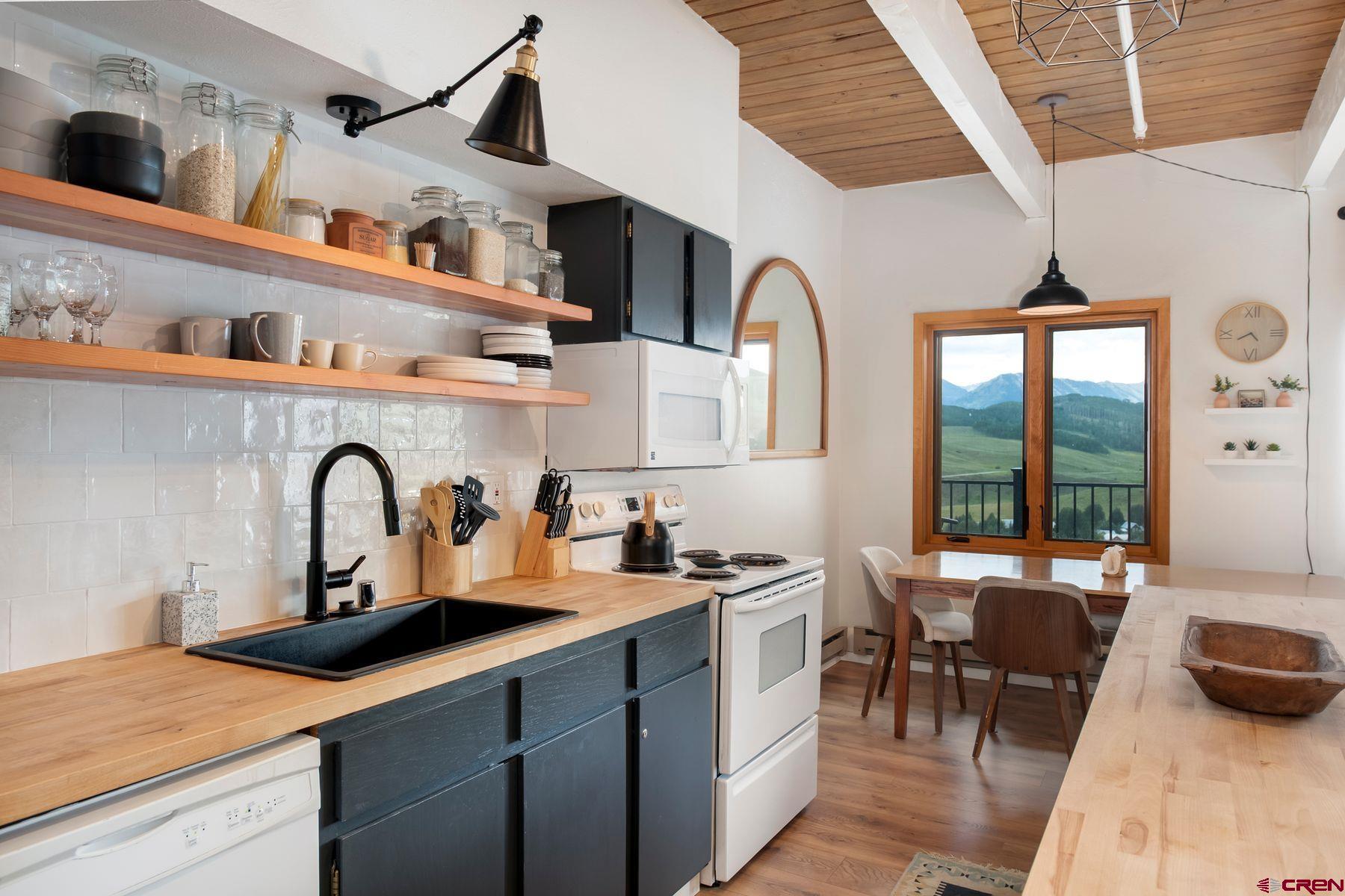 32 Hunter Hill Road, Unit B204 Crested Butte, CO 81225 - Photo 9 of 33 a kitchen with a refrigerator a sink a stove and cabinets