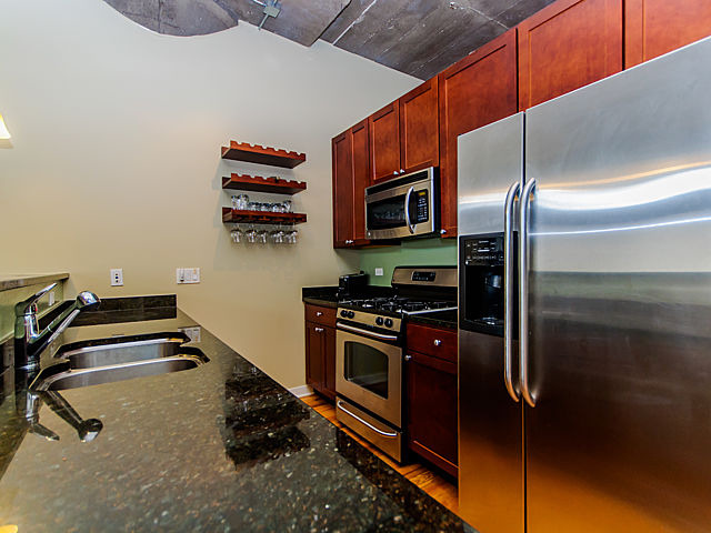 1111 West 15th Street, Unit 111 Chicago, IL 60608 - Photo 3 of 17 a kitchen with stainless steel appliances a stove and a refrigerator