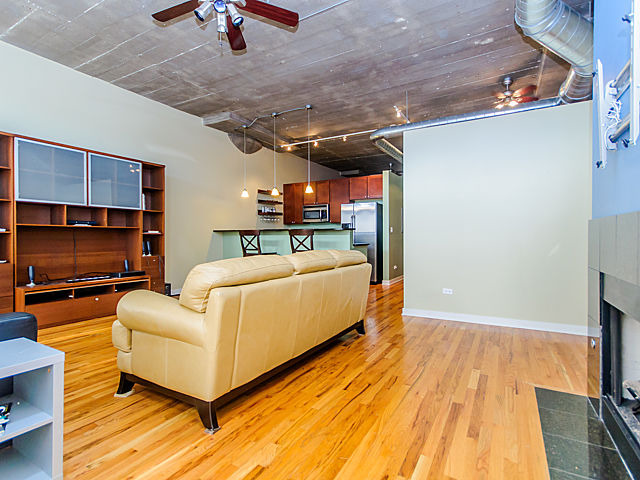 1111 West 15th Street, Unit 111 Chicago, IL 60608 - Photo 6 of 17 a living room with furniture and a flat screen tv