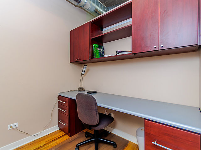 1111 West 15th Street, Unit 111 Chicago, IL 60608 - Photo 9 of 17 a room with wooden floor and furniture