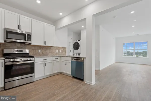 a kitchen with stainless steel appliances granite countertop a refrigerator stove a sink and dishwasher