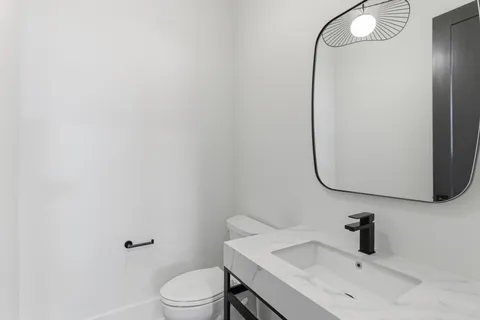 a bathroom with a sink a toilet and a mirror