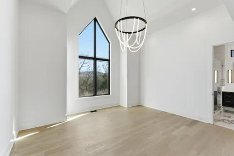 an empty room with wooden floor and mirror
