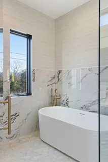 a bathroom with a bathtub and next to a window