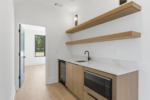 a view of a room with a ceiling fan and wooden floor