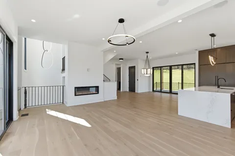 a view of an empty room with window and wooden floor