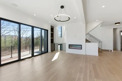 a view of a livingroom with furniture wooden floor fan and window