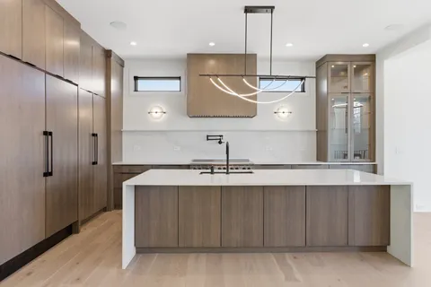 a kitchen with stainless steel appliances granite countertop a sink a stove and a refrigerator