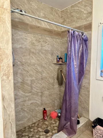 a bathroom with a toilet and a shower curtain