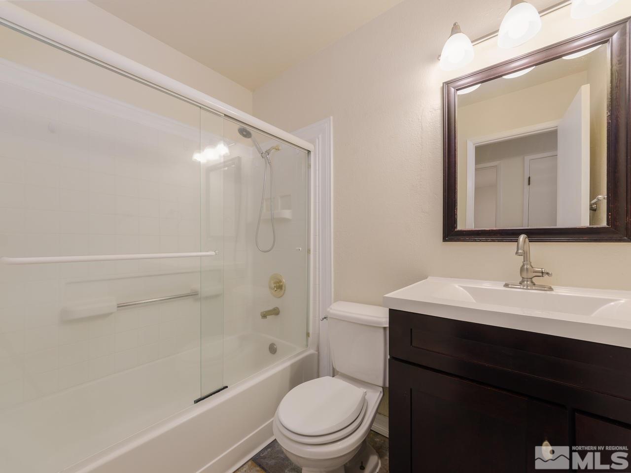 4620 Azalea Drive Reno, NV 89502 - Photo 13 of 19 a bathroom with a toilet a sink a mirror and shower