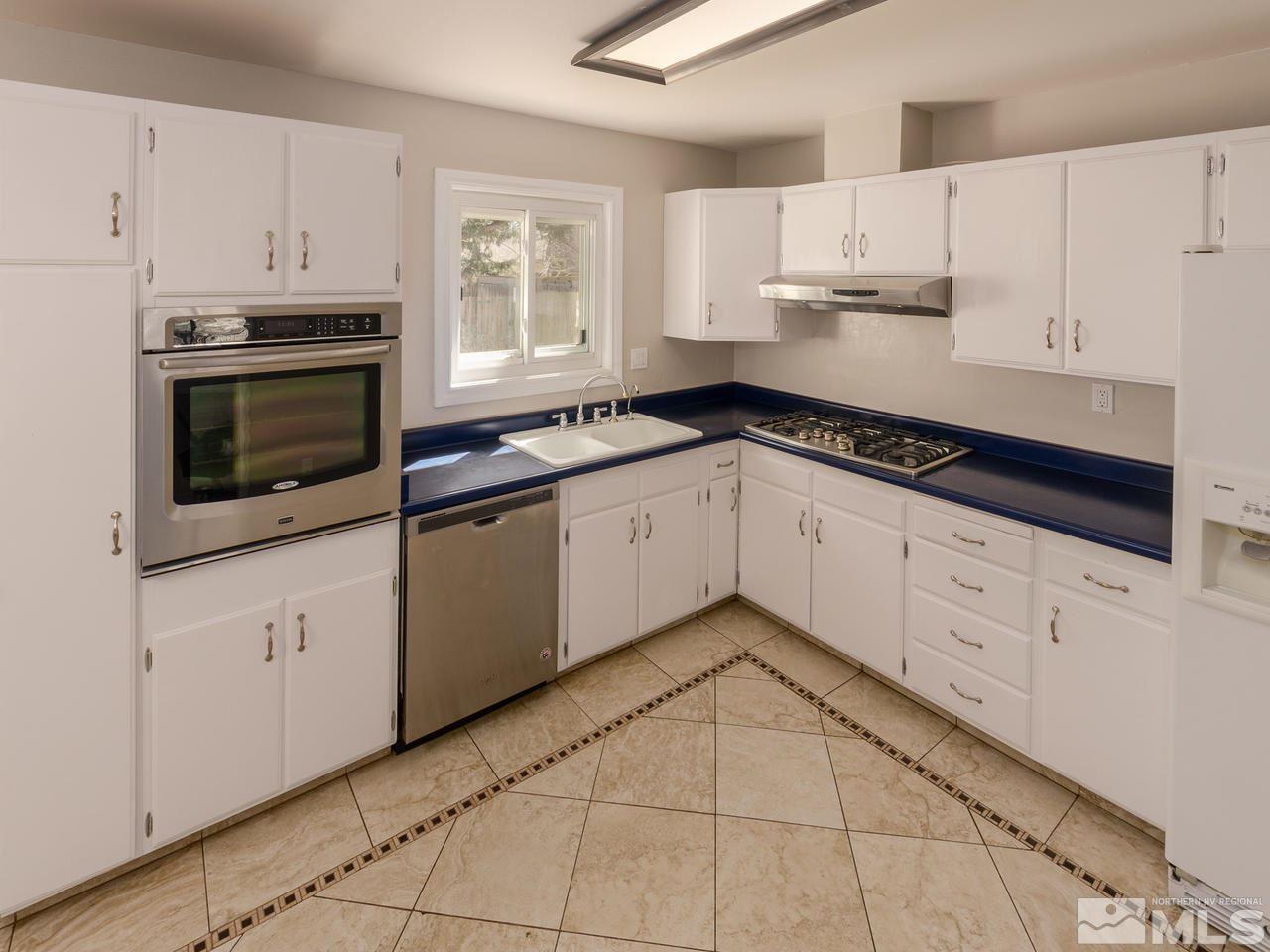 4620 Azalea Drive Reno, NV 89502 - Photo 4 of 19 a kitchen with granite countertop white cabinets white stainless steel appliances with a sink and dishwasher