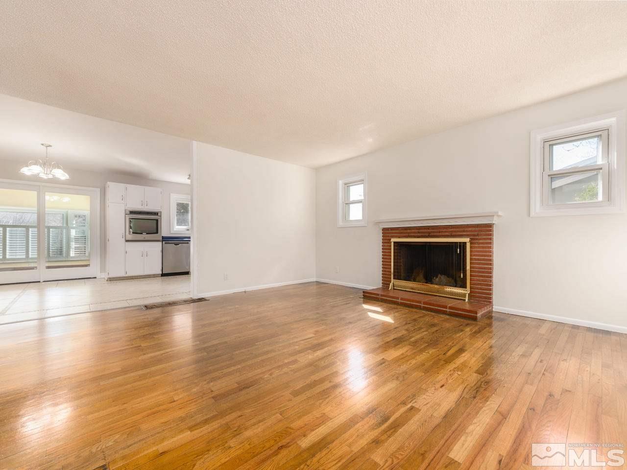 4620 Azalea Drive Reno, NV 89502 - Photo 6 of 19 a view of empty room with wooden floor and fireplace