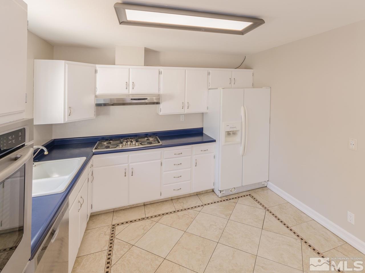 4620 Azalea Drive Reno, NV 89502 - Photo 7 of 19 a kitchen with granite countertop white cabinets and white appliances