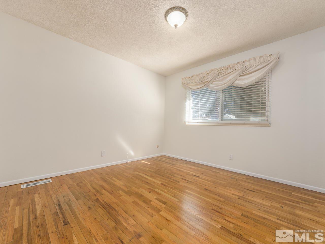 4620 Azalea Drive Reno, NV 89502 - Photo 10 of 19 an empty room with wooden floor and windows
