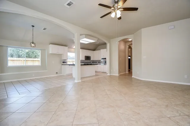 a kitchen with granite countertop a sink a stove top oven and cabinets
