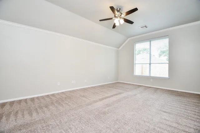 an empty room with a window and a ceiling fan