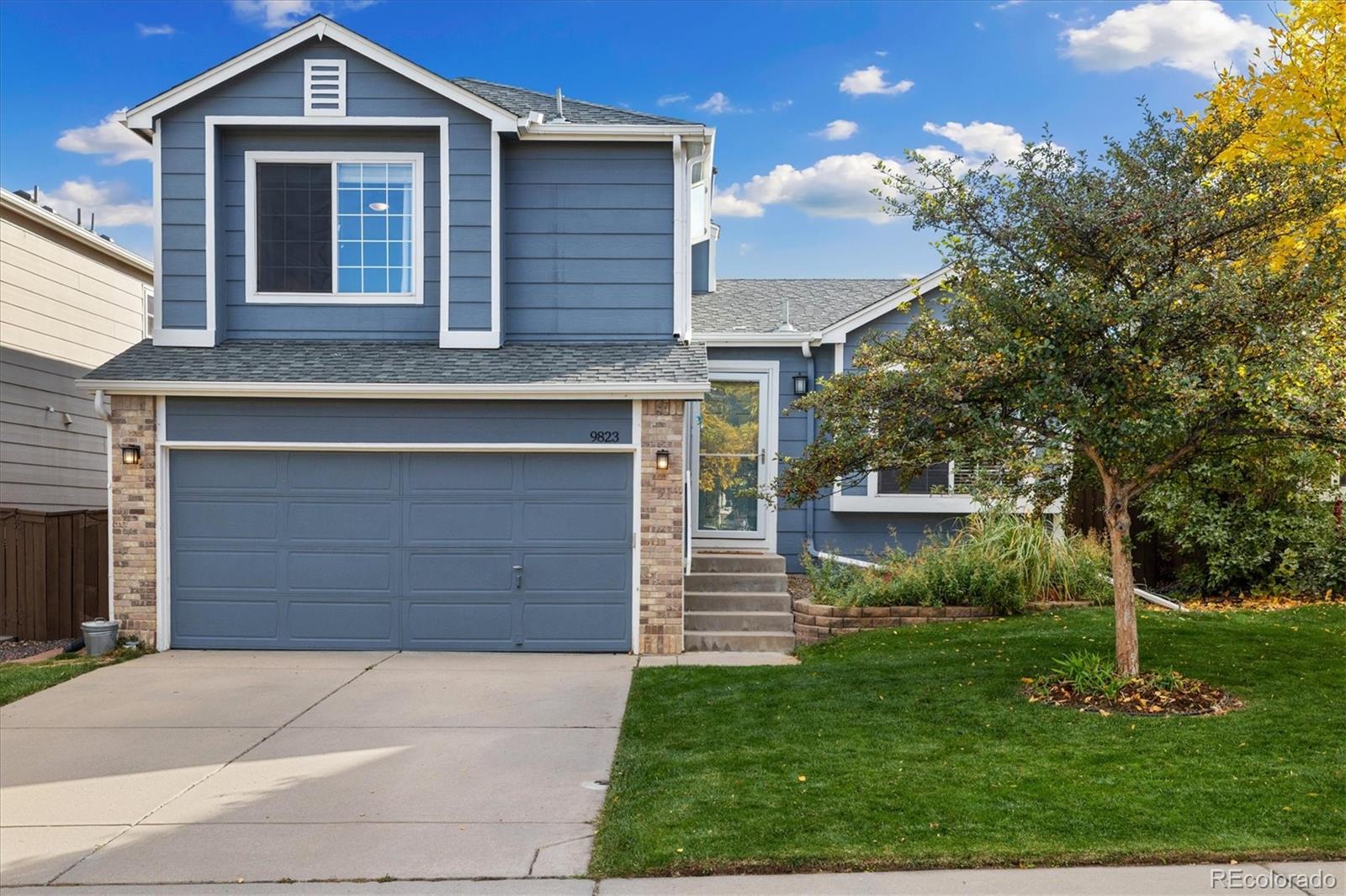 9823 South Castle Ridge Circle Highlands Ranch, CO 80129 - Photo 2 of 46 a front view of a house with a yard and garage