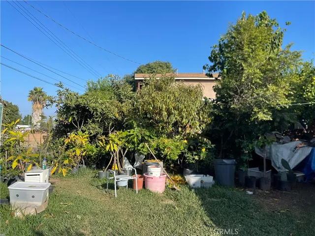 a backyard of a house with table and chairs potted plants