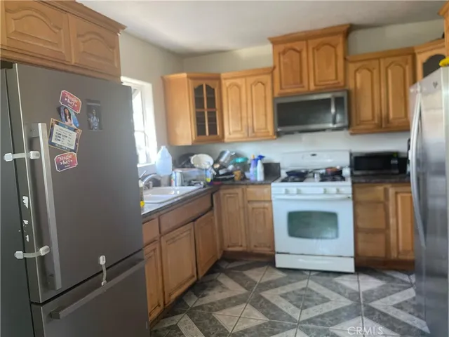 a kitchen with stainless steel appliances granite countertop a stove a sink and a refrigerator