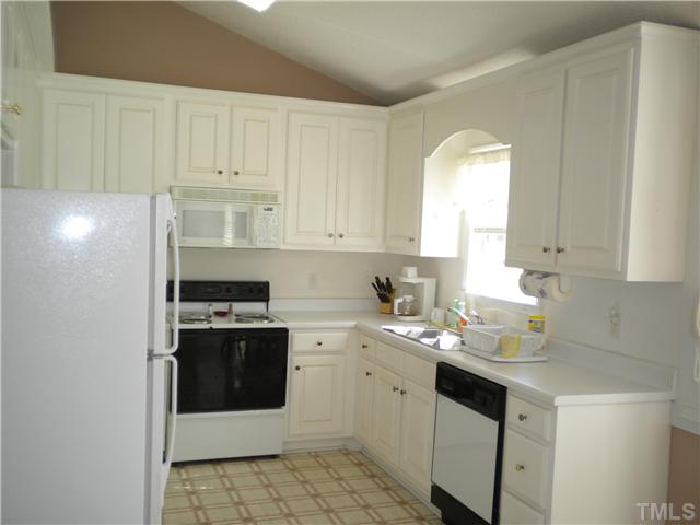 115 Forest Ridge Drive Willow Spring, NC 27592 - Photo 3 of 17 a kitchen with a sink stove and white cabinets