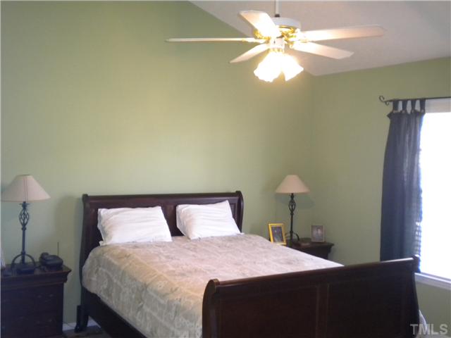 115 Forest Ridge Drive Willow Spring, NC 27592 - Photo 9 of 17 a bedroom with a bed and a chandelier
