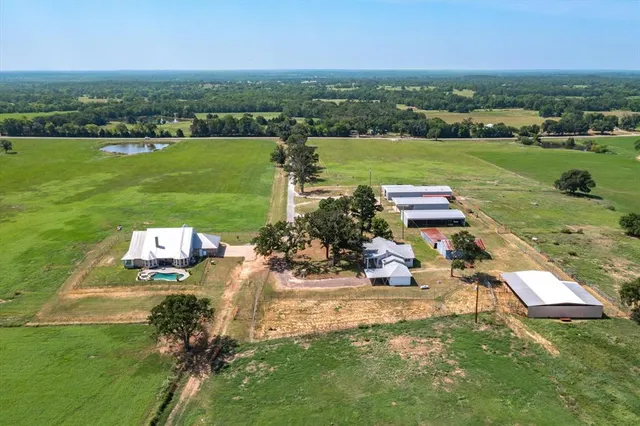 an aerial view of a house with a yard and lake view